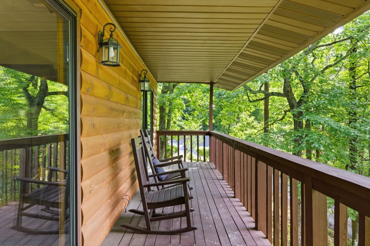 Rocking chairs on the covered porch looking into the trees